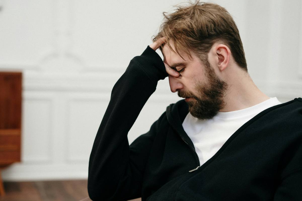 Un paziente in una seduta psichiatrica che si regge la fronte