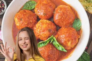 Donna che fa ok con la mano e polpette al sugo nello sfondo