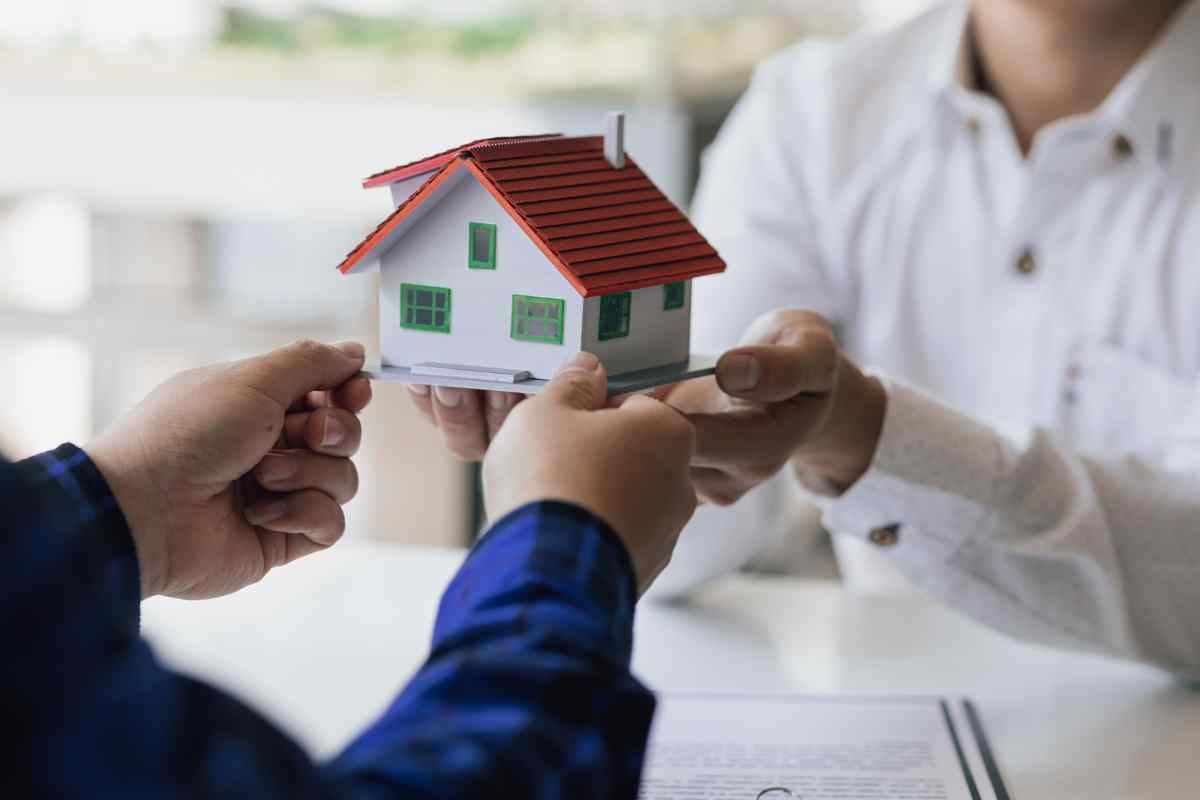 persone si scambiano modellino casa