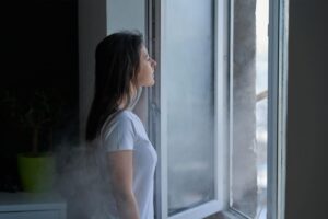 Donna davanti a finestra aperta