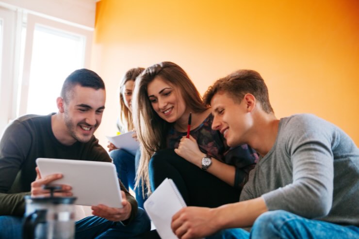 ragazzi sorridenti che guardano tablet