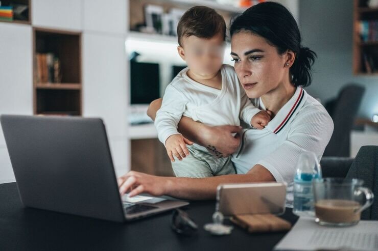 mamma con bimbo in braccio davanti al pc 