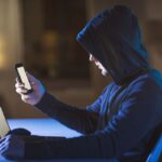 hacker con tablet e smartphone in mano