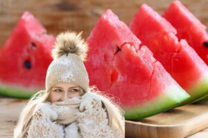 fette di anguria e donna con sciarpa e cappello