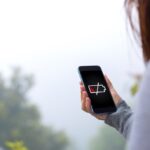donna con telefono con batteria scarica
