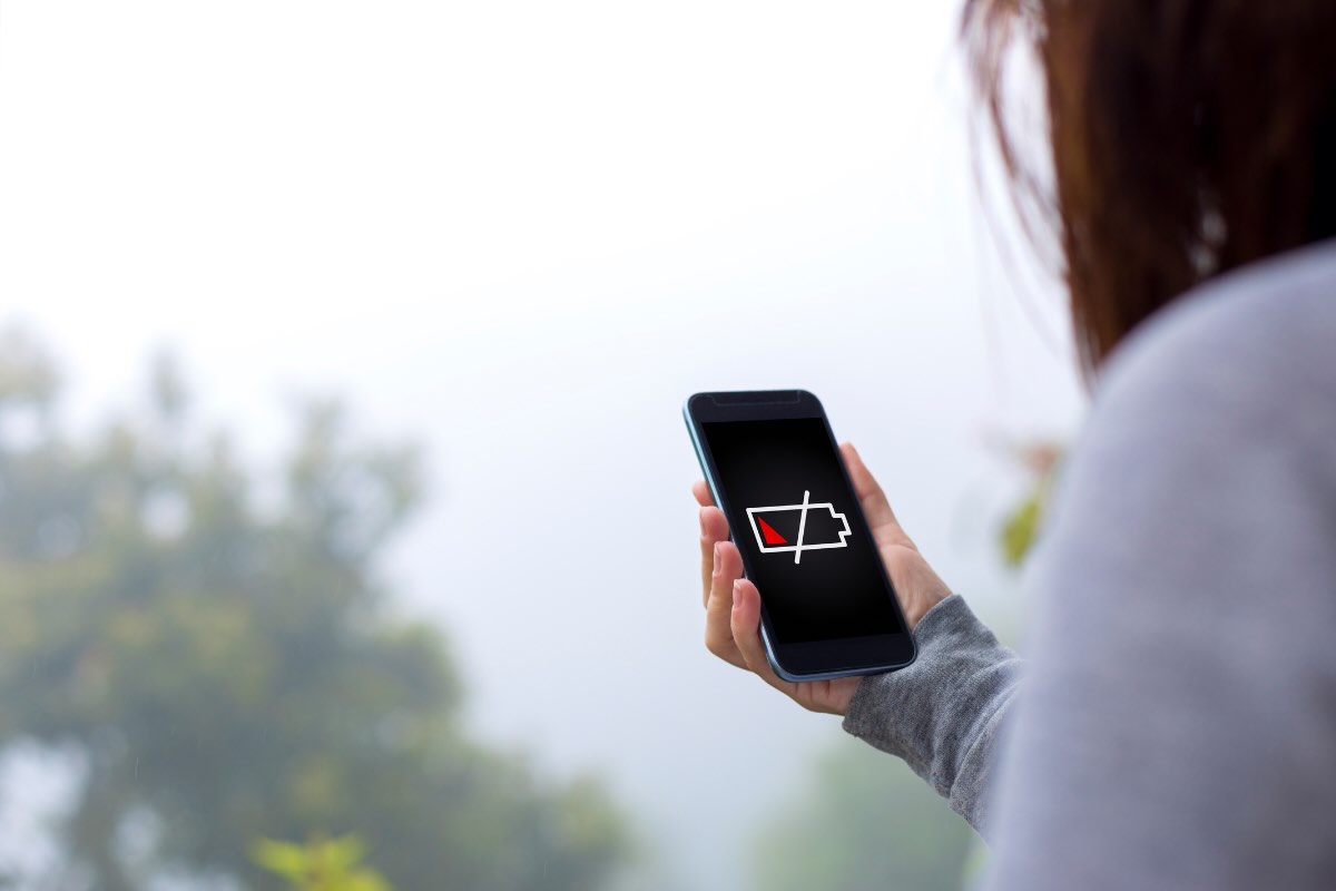 donna con telefono con batteria scarica