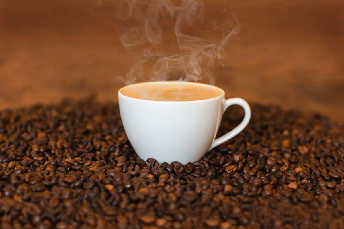 Tazzina di caffè su chicchi di caffè