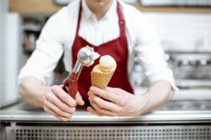 Gelataio mette pallina gelato nel cono