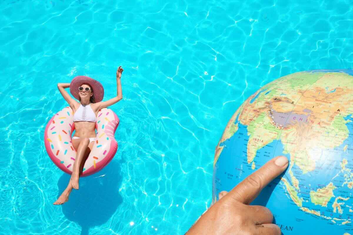 Donna su salvagente in piscina, dito indica su mappamondo
