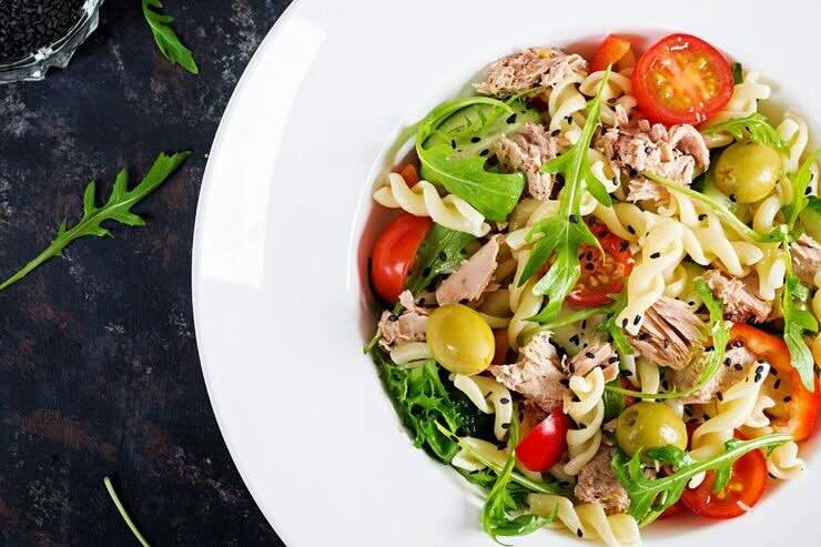 Piatto con fusilli, rucola, pomodori, tonno e olive 