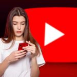 Donna con cellulare, logo YouTube